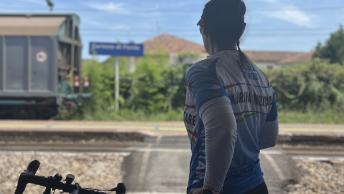 Una ciclista sui binari in attesa del treno di ritorno